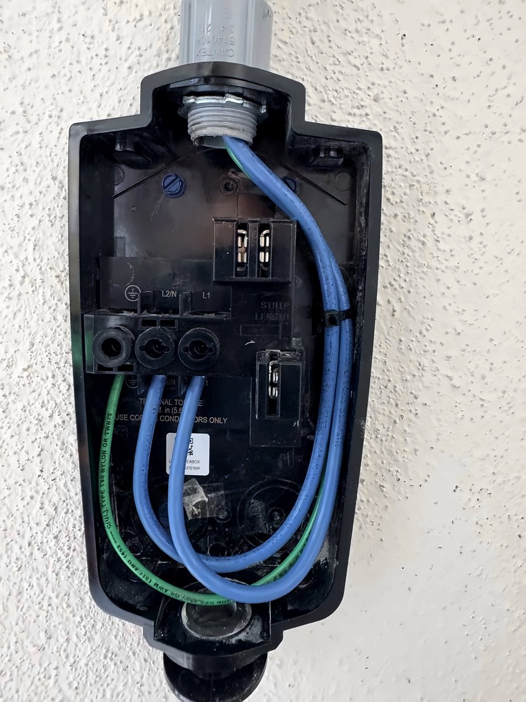 Open EV charger wiring box with 240-volt wiring during installation