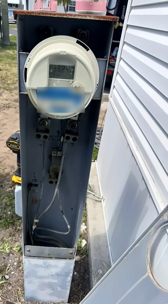 Old, weathered meter pedestal beside a mobile home, before replacement